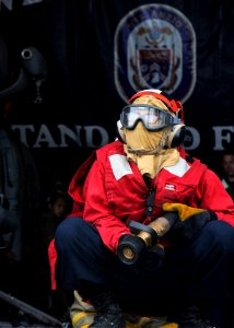 US Navy 110711-N-YM590-004 Damage Controlman Fireman Alex Burgos stands by to fight a simulated fire on the flight deck of the guided-missile cruis