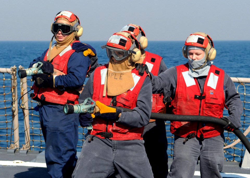 US Navy 110713-N-IO627-002 Sailors handle a fire hose during a flight deck fire drill aboard the guided-missile destroyer USS Curtis Wilbur (DDG 54