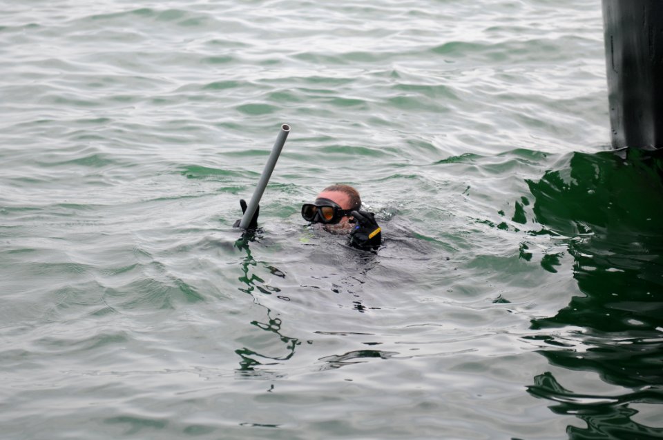 US Navy 110711-N-MN220-220 Navy Diver 2nd Class Nick Barna, a basic diver assigned to Navy Dive Locker Guantanamo, prepares to go underwater to per