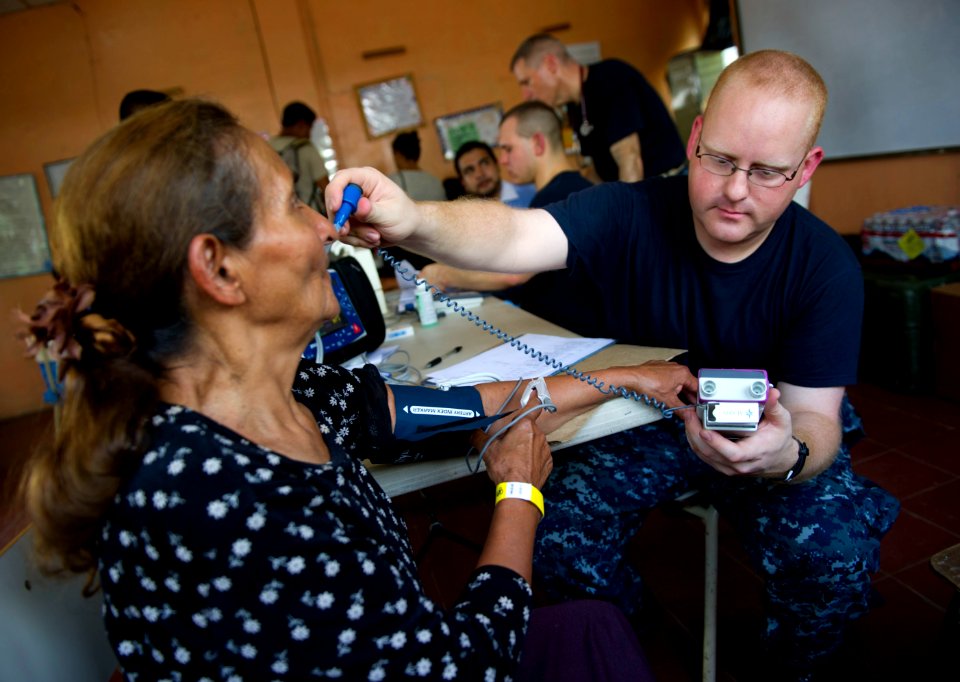US Navy 110714-N-RM525-083 Hospital Corpsman 3rd Class Shannon Sensenig, from Terre Hill, Pa., checks a woman's temperature at a pre-screening vita