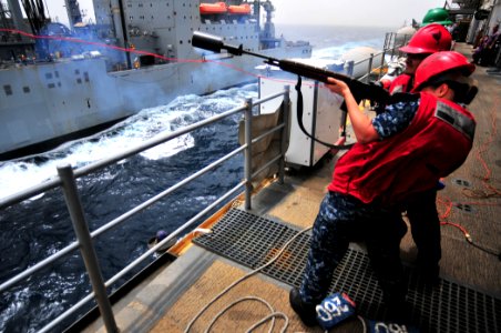 US Navy 110711-N-ZS026-157 Gunner's Mate Seaman Megan Halliburton fires a shot line from the amphibious assault ship USS Boxer (LHD 4) to the Milit