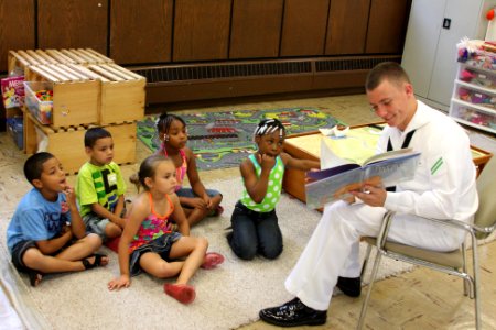 US Navy 110713-N-NT881-125 eaman Apprentice Chris Donahue, assigned to Navy Operation Support Center Rochester, reads to children at the Cameron Co photo