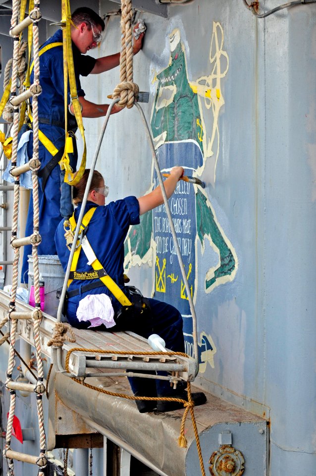 US Navy 110713-N-RC734-125 Seaman Recruit Samuel Harper, left, and Seaman Apprentice Naomi Bentley touch up a mural aboard the amphibious dock land