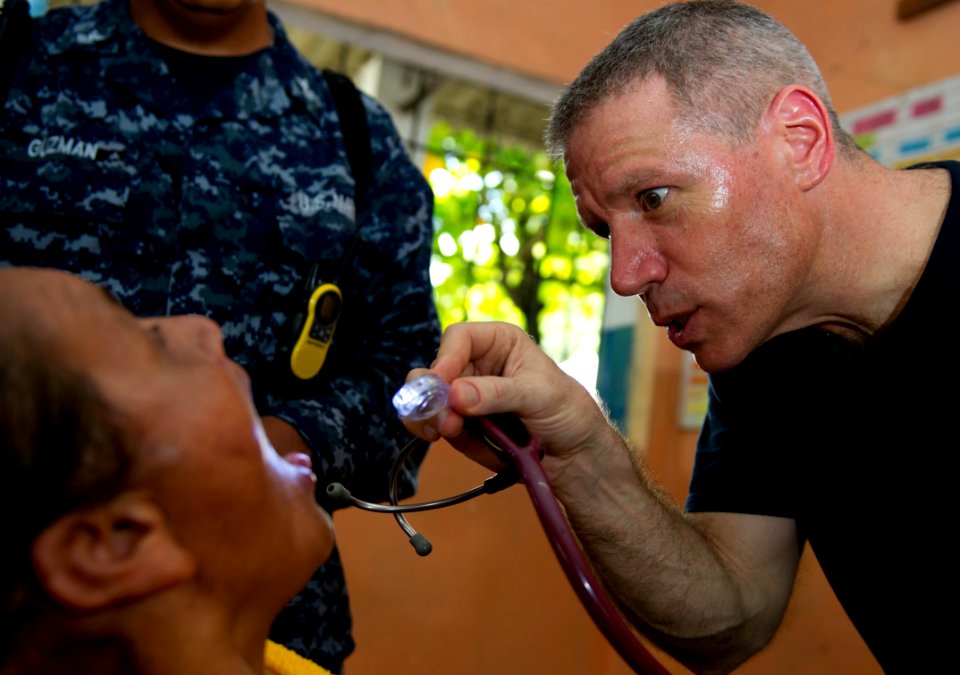 US Navy 110714-N-RM525-097 Capt. Michael Mazzilli, from Montrose, N.Y., examines a woman at a pre-screening vital signs station during a Continuing