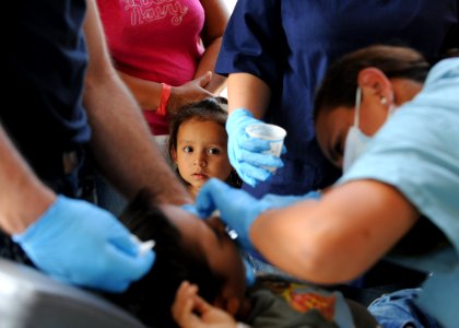 US Navy 110715-N-NY820-224 Peruvian Navy Lt. Rossi Marian works on a dental patient as his sister watches during a Continuing Promise 2011 communit photo