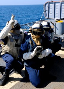 US Navy 110715-N-KB052-563 Boatswain's Mate 3rd Class John King, leader of hose team three, communicates with the on-scene leader during a crash a photo
