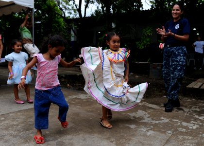 US Navy 110718-N-QD416-407 Hospital Corpsman 2nd Class Paola Foxhoven, from Guayaquil, Ecuador, watches children dance photo