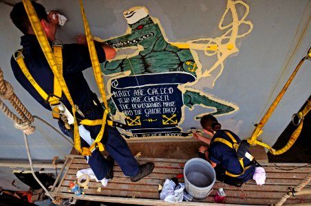 US Navy 110713-N-RC734-112 Seaman Recruit Samuel Harper, left, and Seaman Apprentice Naomi Bentley touch up a mural aboard the amphibious dock land