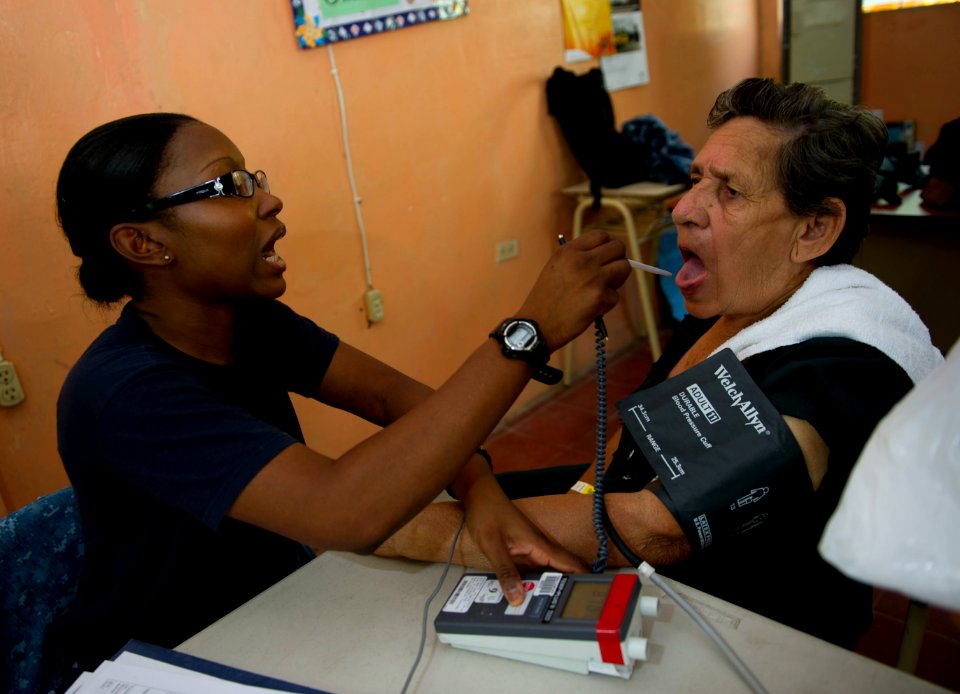 US Navy 110714-N-RM525-060 Hospitalman Seckisiesha Isaac, from New York, prepares to take a woman's temperature at a pre-screening vital signs stat