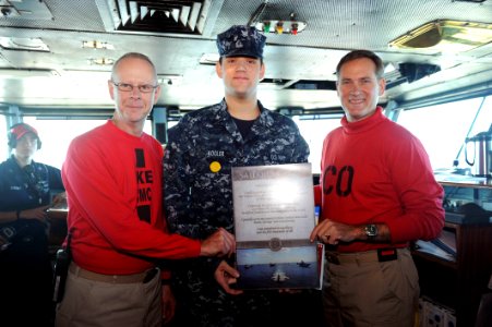 US Navy 110718-N-AU622-083 Mass Communication Specialist 3rd Class Erick Kogler, center, displays a