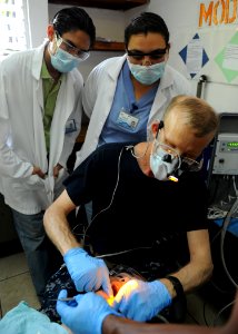 US Navy 110718-N-QD416-054 Salvadoran dentists watch as Capt. Thomas Hudson, from Deerfield, Ill., performs restorative care on a patient's teeth