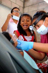 US Navy 110719-F-ET173-051 A girl shows her sister how to