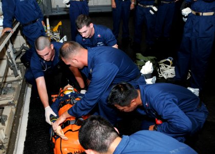 US Navy 110718-N-UE250-022 Sailors assigned to the submarine tender USS Frank Cable (AS 40) strap a training dummy into a stretcher during a medica