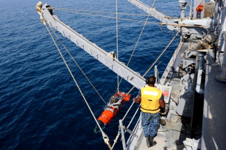 US Navy 110721-N-WL435-047 A Sailor lowers a mine neutralization vehicle into the water to perform mine counter-measure training aboard USS Gladiat