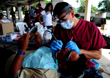 US Navy 110721-N-QD416-033 Hospital Corpsman 1st Class Darwin Flores-Lopez cleans a patient's teeth at the Polideportivo medical site in Acajutla photo