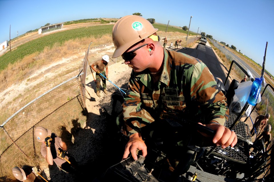 US Navy 110720-N-SN160-113 Equipment Operator 2nd Class Jason Swart, assigned to Naval Mobile Construction Battalion (NMCB) 74, lays fresh asphalt
