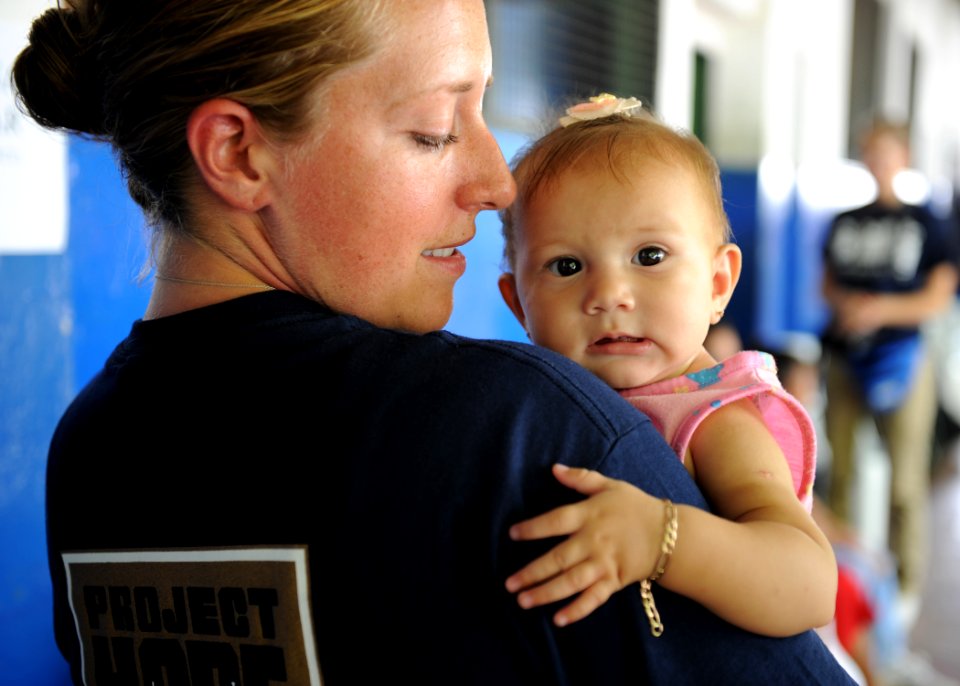 US Navy 110718-N-QD416-121 Kate Plenert, a volunteer with the non-govermental organization, Project Hope, holds an infant