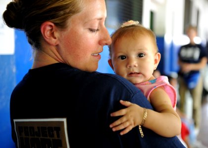 US Navy 110718-N-QD416-121 Kate Plenert, a volunteer with the non-govermental organization, Project Hope, holds an infant