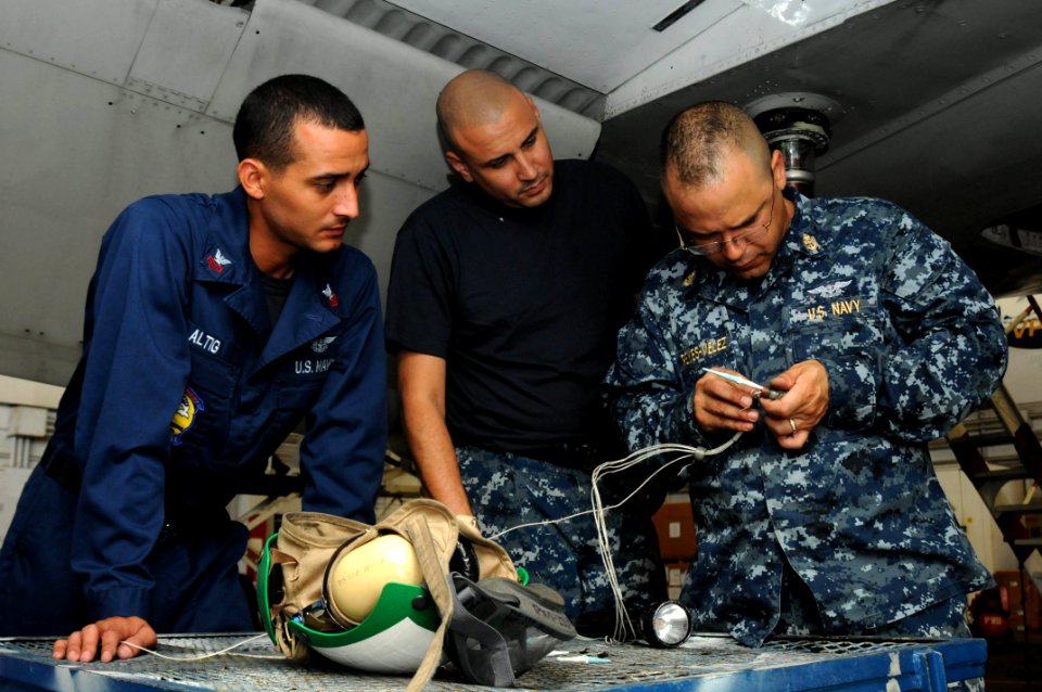 US Navy 110721-N-SP676-172 Aviation Electrician 1st Class Carlos Altig, left, and Aviation Electrician 2nd Class Adam Valverde observe Chief Aviati