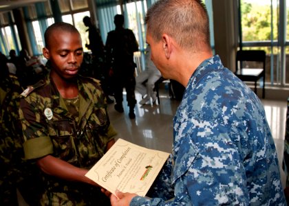 US Navy 110722-N-OV802-127 Cmdr. Angel Cruz shakes hands with Uganda navy 2nd Sgt. Antonio Paude during the Africa Partnership Station (APS) East K