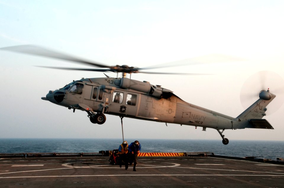 US Navy 110721-N-YX169-366 Aviation Boatswain's Mate (Handling) Airman Opie Madlangbayan, left, and Midshipman 3rd Class Seamus Fish scramble away