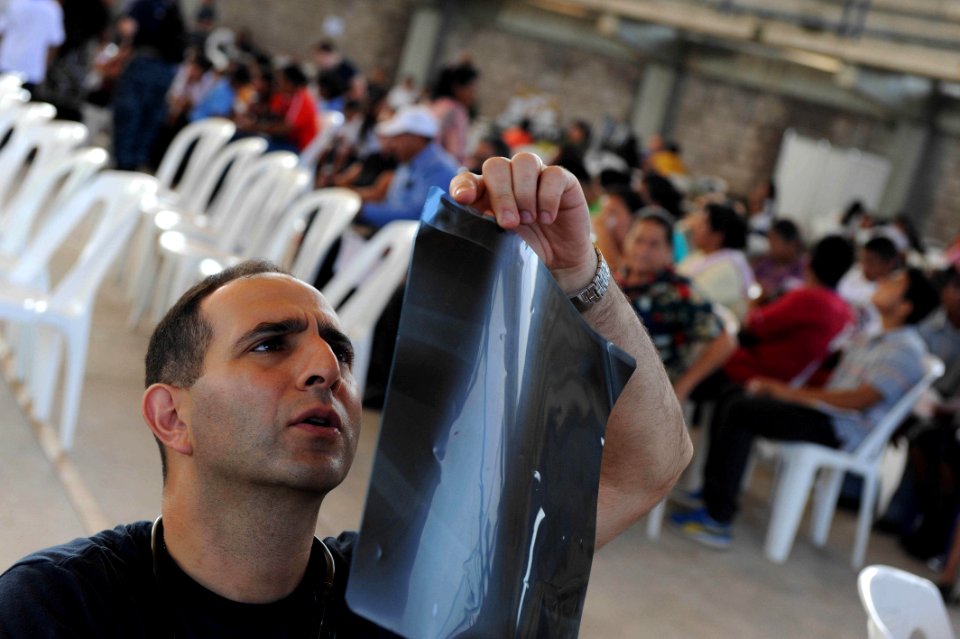 US Navy 110719-F-ET173-096 Cmdr. Michael Monsour, from Fall River, Mass., reviews a patient's X-ray during a Continuing Promise 2011 community serv