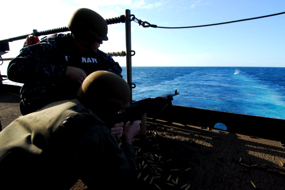 US Navy 110725-N-AW206-074 Air Force Col. Chris Stockton fires an M240B machine gun from the fantail of the aircraft carrier USS George Washington