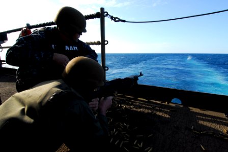 US Navy 110725-N-AW206-074 Air Force Col. Chris Stockton fires an M240B machine gun from the fantail of the aircraft carrier USS George Washington