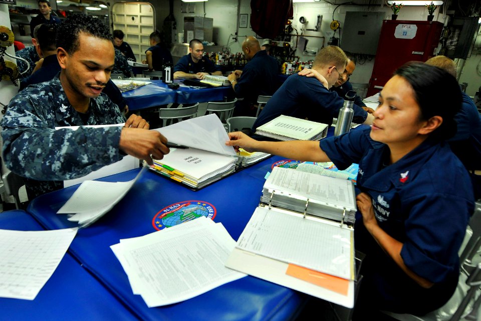US Navy 110722-N-EE987-071 Interior Communications Electrician 1st Class Jeremy Dewalt, left, from San Antonio, reviews Damage Controlman 1st Class