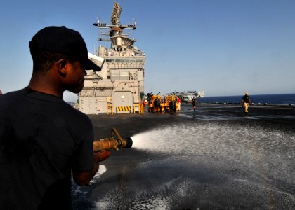 US Navy 110723-N-KA046-004 Aviation Boatswain's Mate (Handling) 1st Class Devon Caldeira participates in a flight deck scrub down aboard the multip