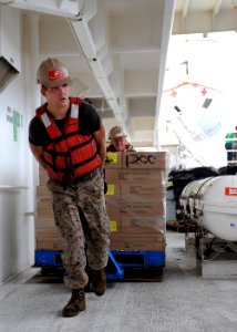 US Navy 110726-F-ET173-291 Cpl. Joe Everetts, front, and Construction Mechanic 1st Class Rodney Chason move cargo to a holding area