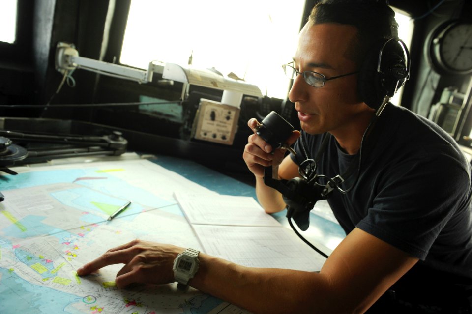 US Navy 110720-N-WL435-079 Electronics Technician 1st Class Juan Mendez records bearings on the bridge during a sea and anchor evolution aboard USS