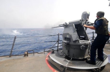 US Navy 110722-N-XQ375-242 Gunner's Mate 3rd Class Travis Hoffman fires a MK 38 25mm machine gun during a gun exercise aboard the guided-missile de