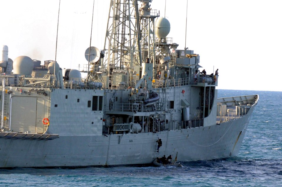 US Navy 110721-N-IO627-081 A Sailor assigned to the guided-missile destroyer USS Curtis Wilbur (DDG 54) climbs from a rigid-hull inflatable boat