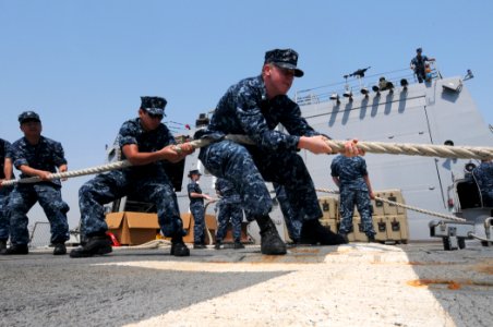 US Navy 110725-N-TB177-095 Sailors heave a line aboard the guided-missile destroyer USS Truxtun (DDG 103) as the ship pulls into Mina Salam, Bahrai