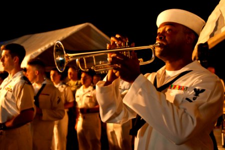 US Navy 110727-N-CZ945-061 Musician 3rd Class Michael Bookman plays the trumpet while performing the song Echo Taps at a Big Top reception aboard U