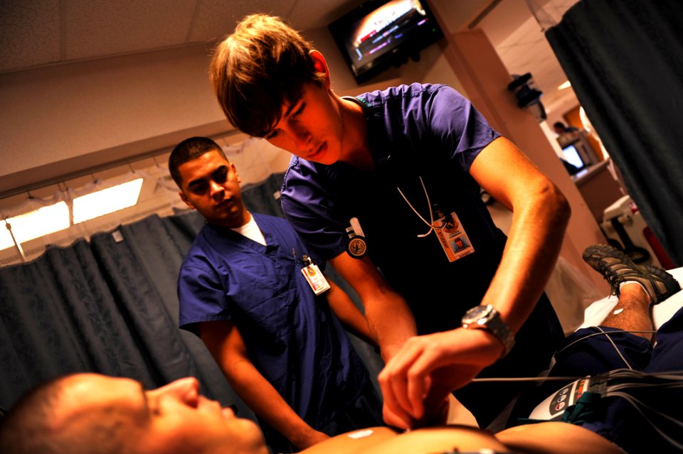 US Navy 110727-N-YR391-008 Hospitalman Edwin Torres instructs Jurgen Comberg, a college preparatory medical arts magnet high school student attendi