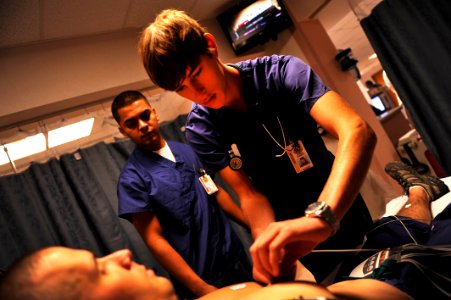 US Navy 110727-N-YR391-008 Hospitalman Edwin Torres instructs Jurgen Comberg, a college preparatory medical arts magnet high school student attendi