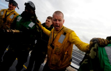 US Navy 110726-N-ZZ999-163 Aviation Boatswain's Mate (Handling) 3rd Class Michael Nicholas instructs Sailors on maneuvering fire hoses during fligh