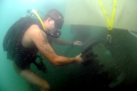 US Navy 110726-N-XD935-271 Navy Diver 2nd Class Zach Dojaquez, assigned to Mobile Diving and Salvage Unit (MDSU) 2, maintains positive control of a photo
