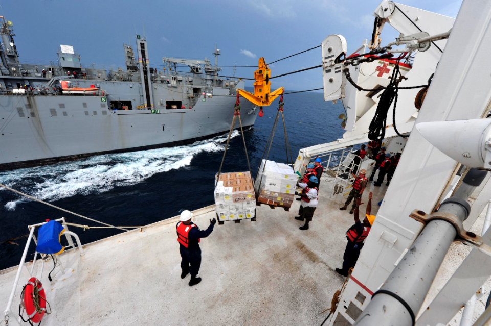 US Navy 110726-F-NJ219-206 Personnel embarked aboard USNS Comfort (T-AH 20) accept cargo from USNS Lewis and Clark (T-AKE 1) during an underway rep