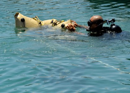 US Navy 110726-N-KB666-203 Able Body Seaman Omar Albury, a diver assigned to the Royal Bahamas Defense Force, transports an engine during a lift-ba