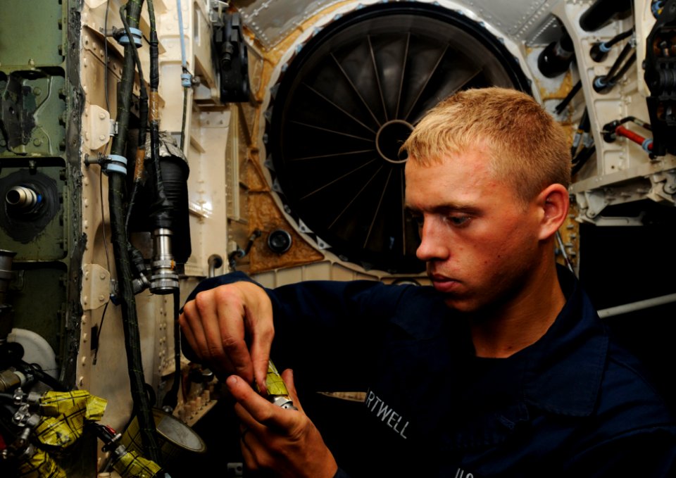 US Navy 110727-N-XE109-021 Aviation Structural Mechanic (Equipment) Airman Michael D. Hartwell maintains a fire extinguishing system on an F-A-18E