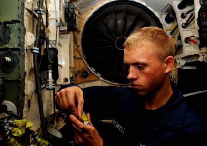US Navy 110727-N-XE109-021 Aviation Structural Mechanic (Equipment) Airman Michael D. Hartwell maintains a fire extinguishing system on an F-A-18E