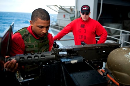 US Navy 110731-N-BT887-050 Aviation Ordnanceman Airman Hector Espinos assembles a .50-caliber machine gun during a training exercise aboard USS Joh photo