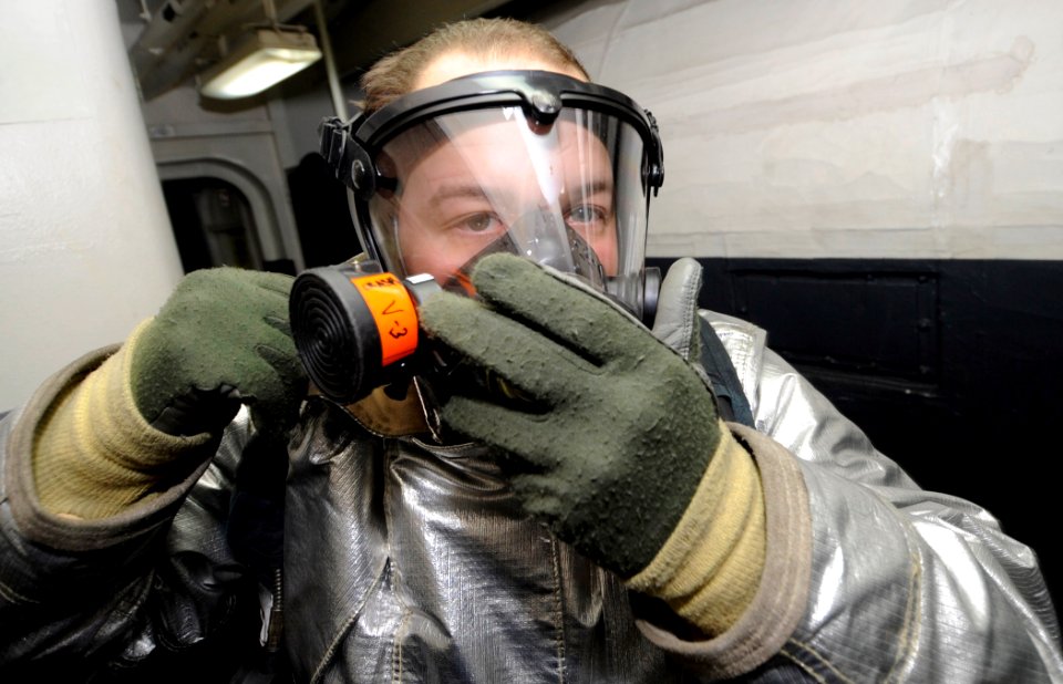 US Navy 110727-N-ZZ999-075 Aviation Boatswain's Mate (Handling) Airman Jordan Jackson ons a self-contained breathing apparatus during a hangar bay