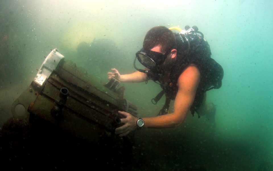 US Navy 110726-N-XD935-248 Navy Diver 2nd Class Zach Dojaquez, assigned to Mobile Diving and Salvage Unit (MDSU) 2, looks for lifting points on a s