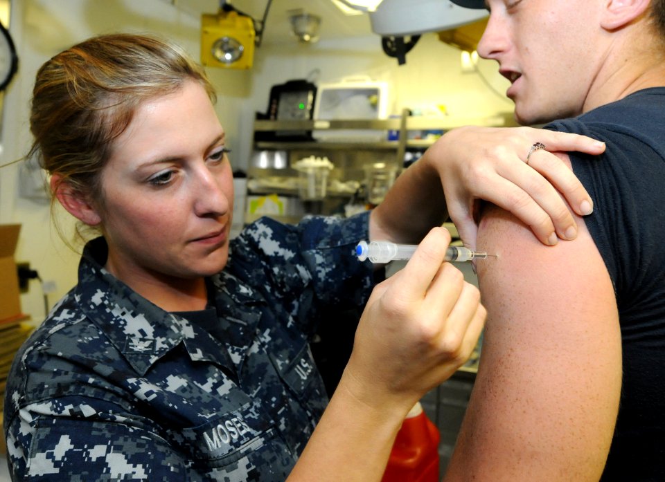 US Navy 110801-N-QL471-012 Hospital Corpsman 3rd Class Kyra Moses administers a vaccination shot to Damage Controlman Fireman Joseph Allen i