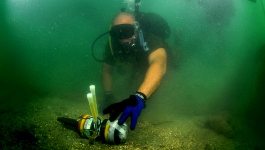 US Navy 110728-N-XD935-177 Able Body Seaman Omar Albury finds an inert training mine on the sea floor utilizing a circle search line during joint d