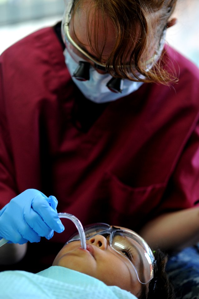 US Navy 110803-N-NY820-199 Hospital Corpsman 1st Class Kimberly Edwards cleans a patient's teeth at the Escuela Fray Casiano de Madrid medical site